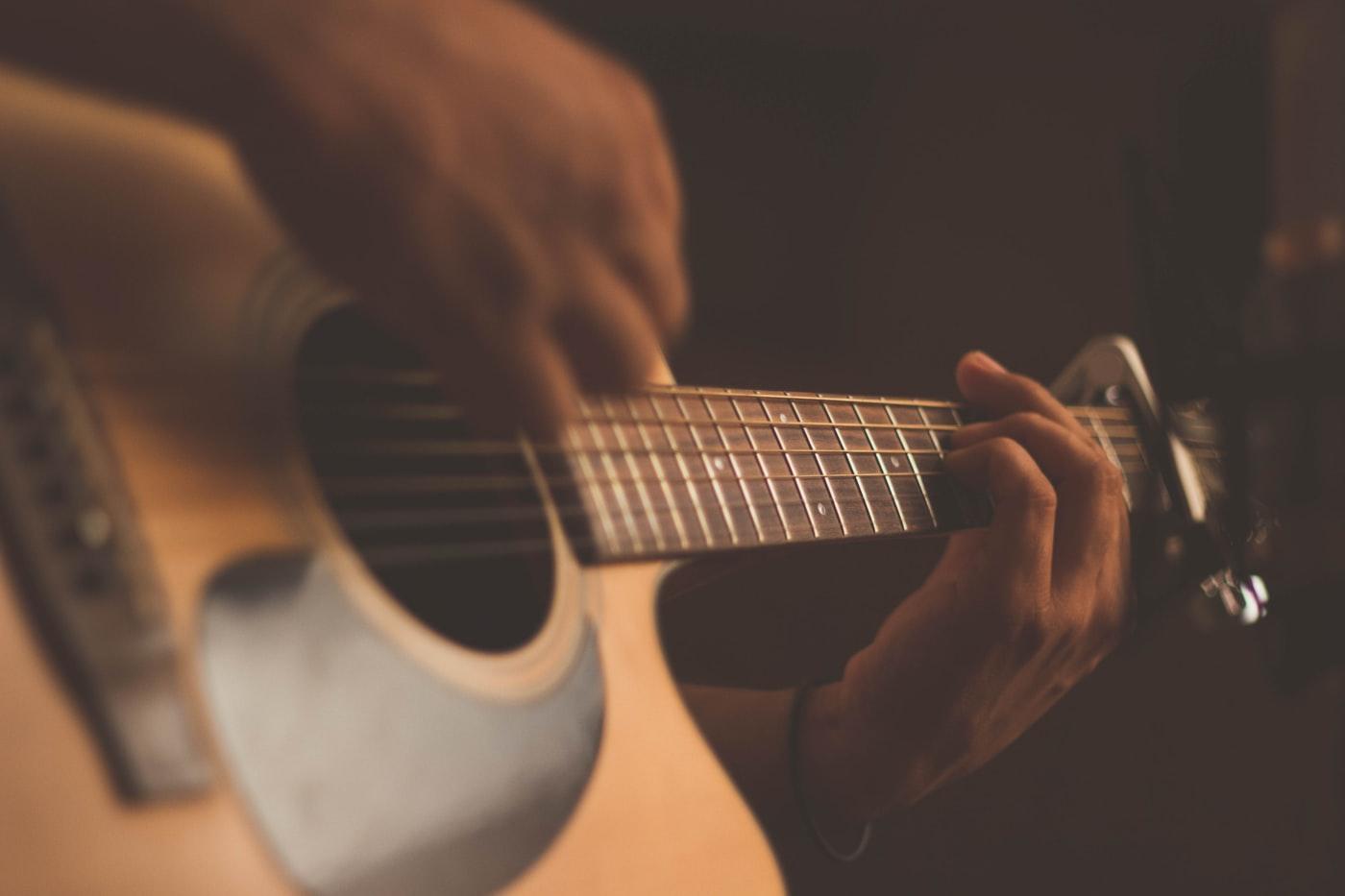Músico tocando guitarra num show de pop rock